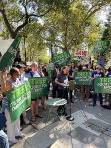 Executive Director, Sarah Charlop-Powers, approaches podium at rally, surrounded with protestors holding "Tree Equity" signs