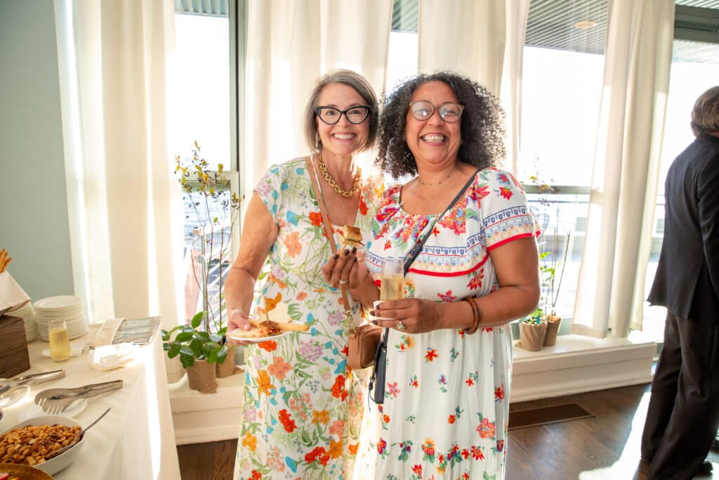 Two smiling attendees in floral dresses at Night for Nature 2023
