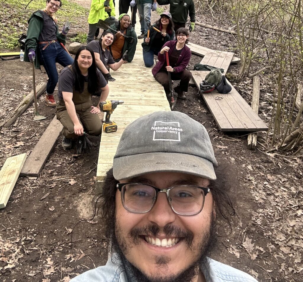 Josh smiling in front of group of trail maintainers