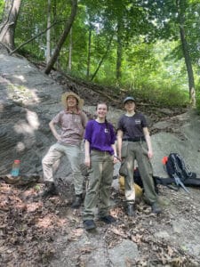 3 interns in forest smiling