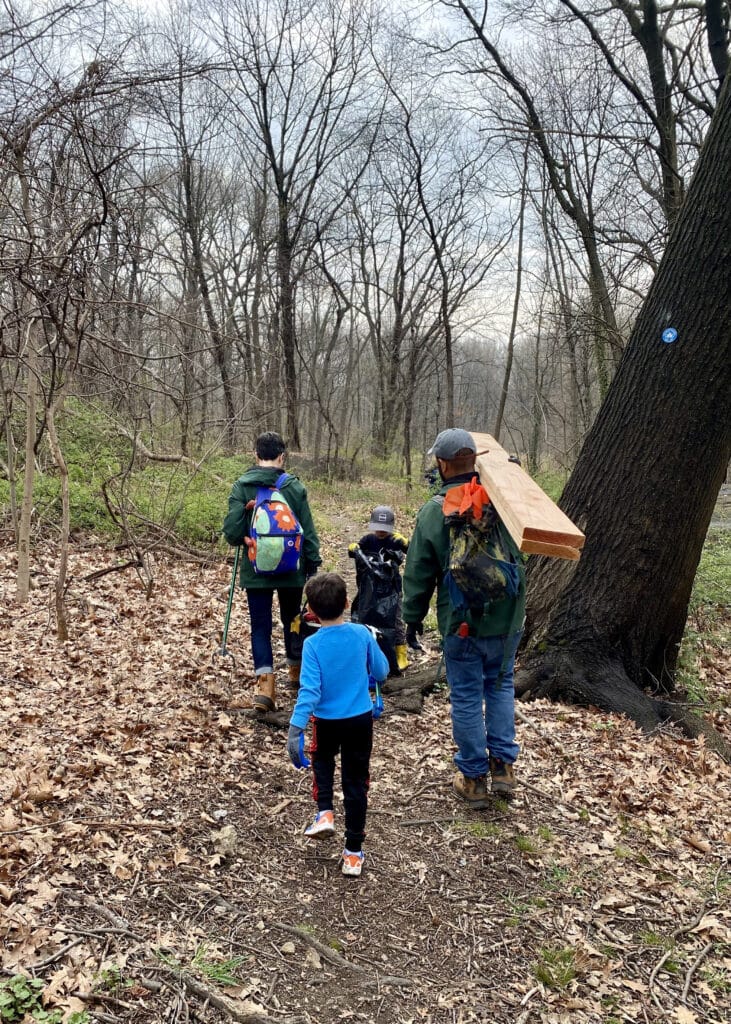 Children and adults walk on forest park in fall