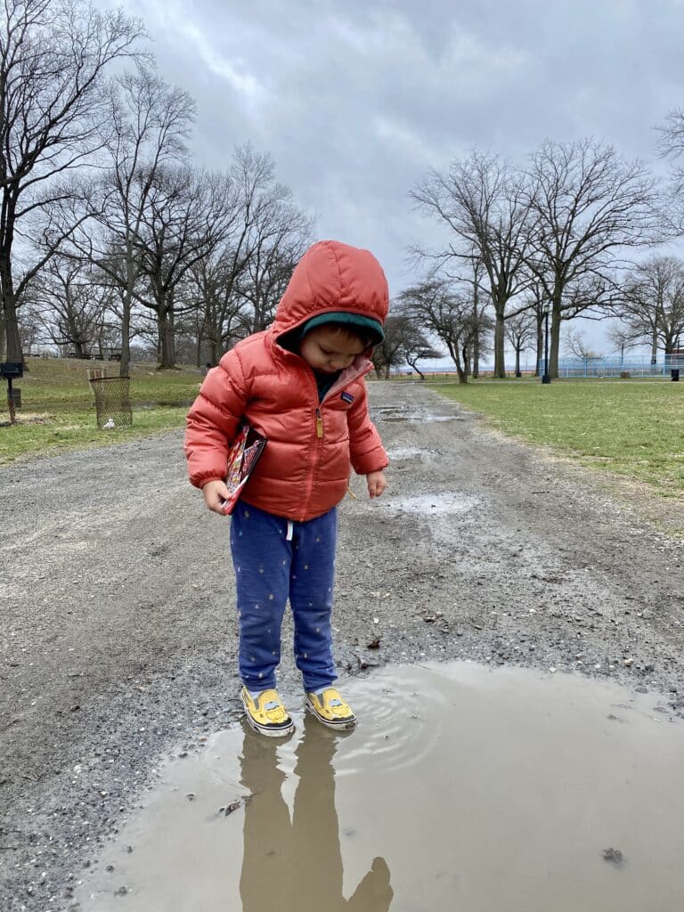 child standing in a puddle