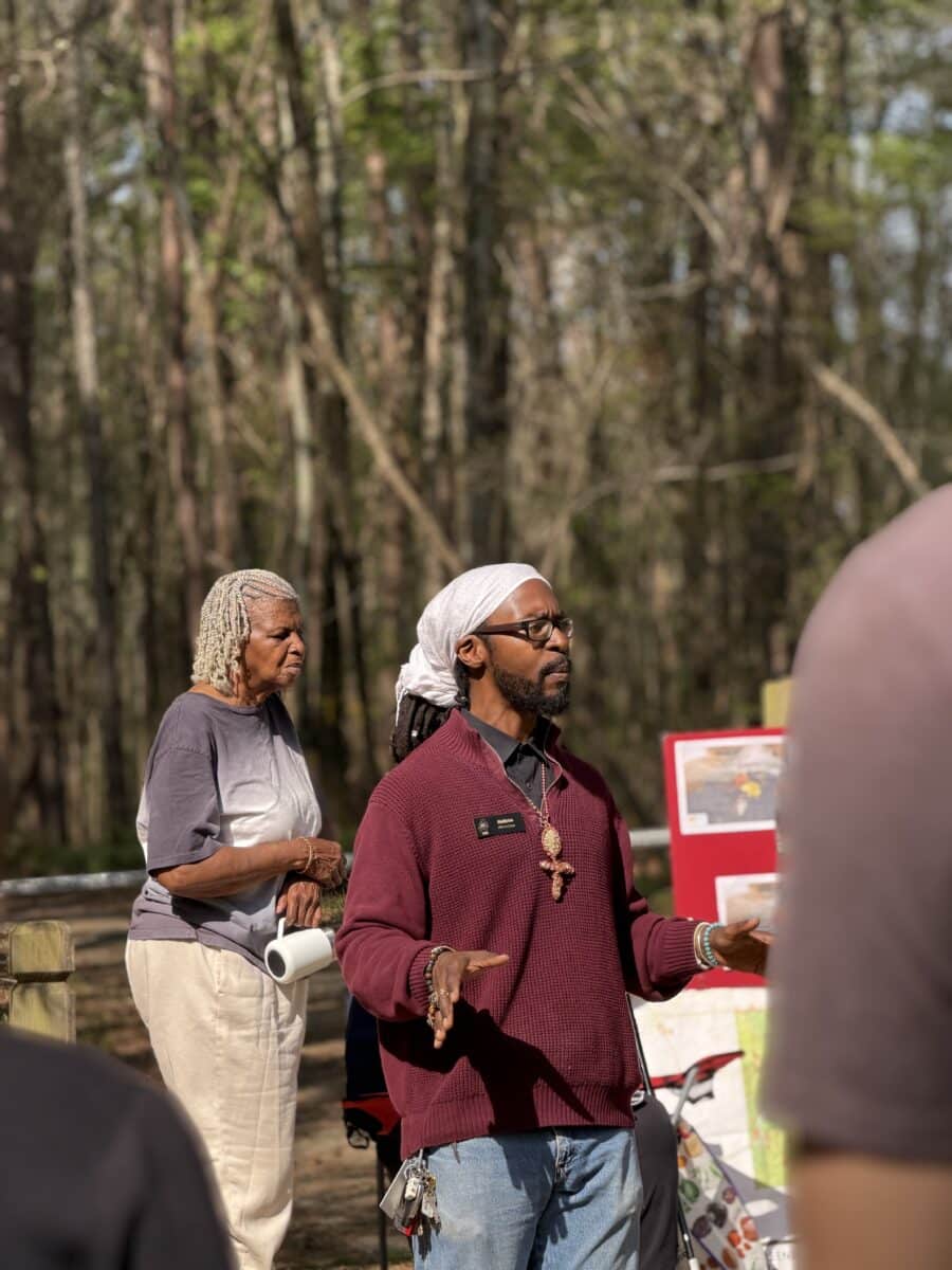 Man talks to group outside in forest