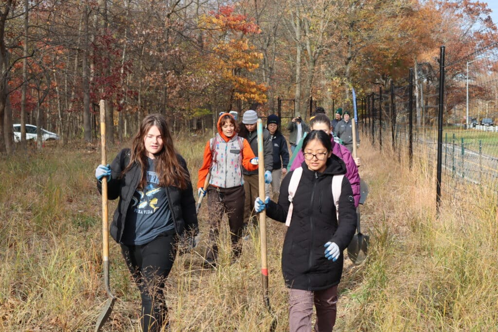 group of people carry shovels
