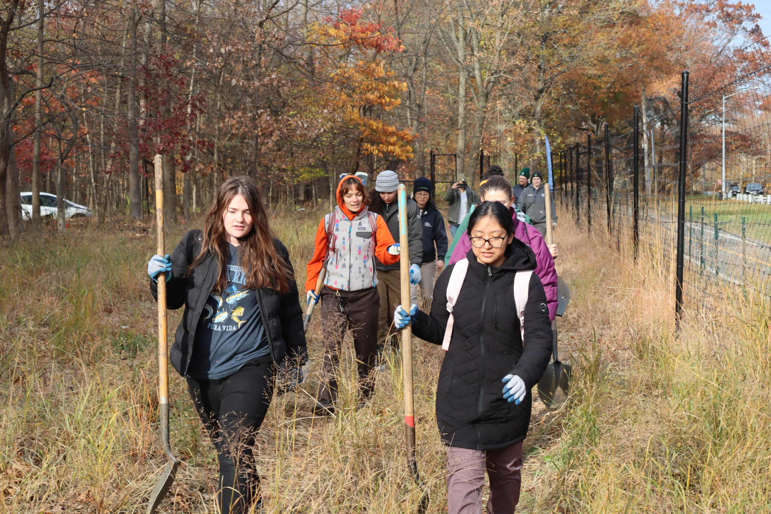 group of people carry shovels